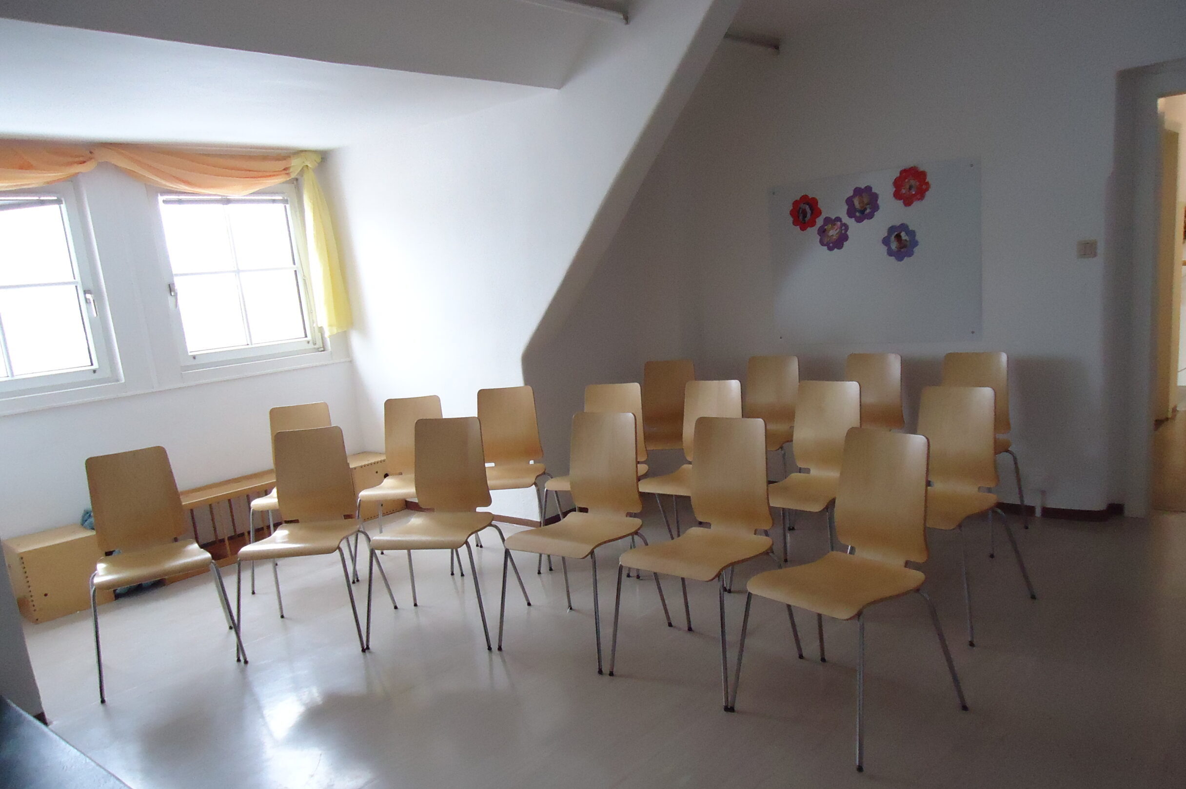 Blick in den Bewegungsraum, wo ein Sesselkreis steht
